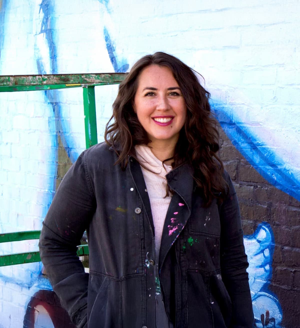 Liz Richter smiling in front of a mural